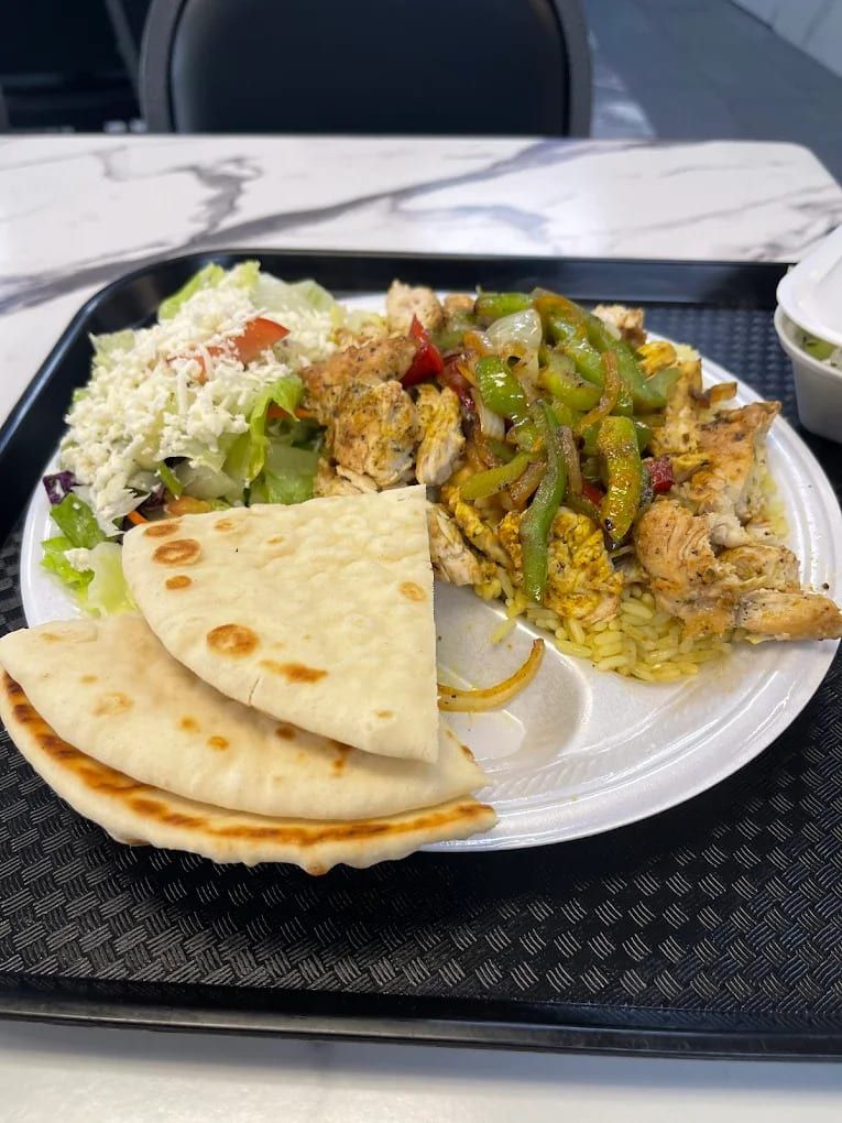 A gyro plate with rice, salad and pita